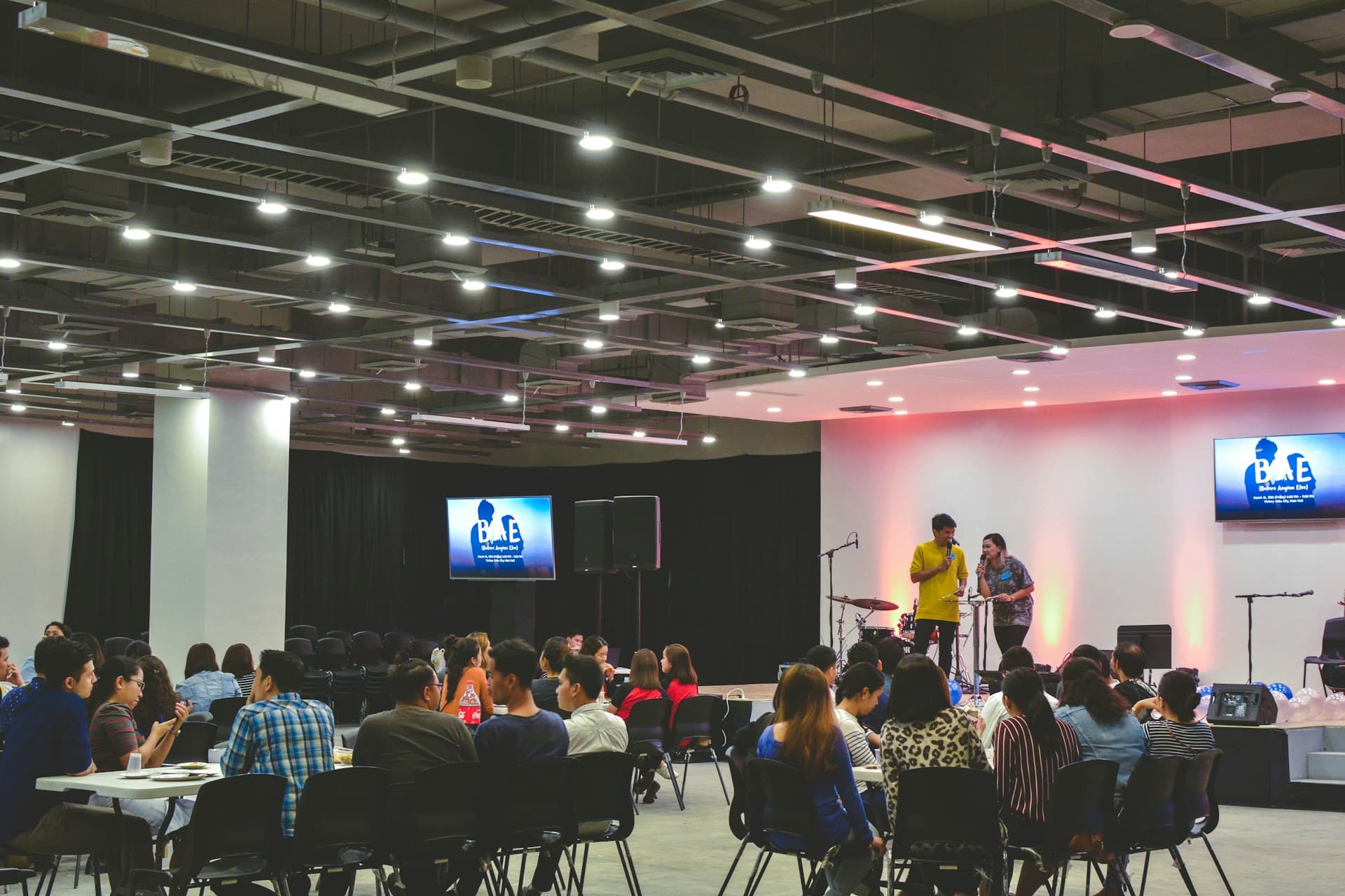 A conference hall with stage and screens during the event