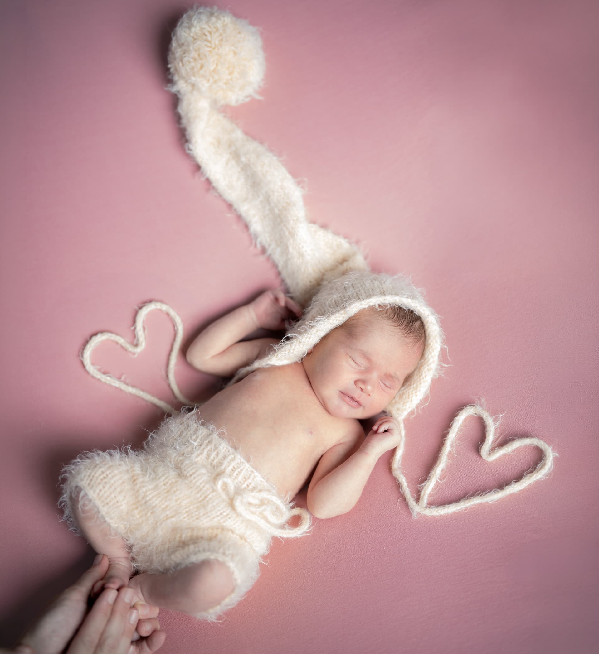 Newborn photoshoot - family hands around the baby, black and white frame, Emma Studio